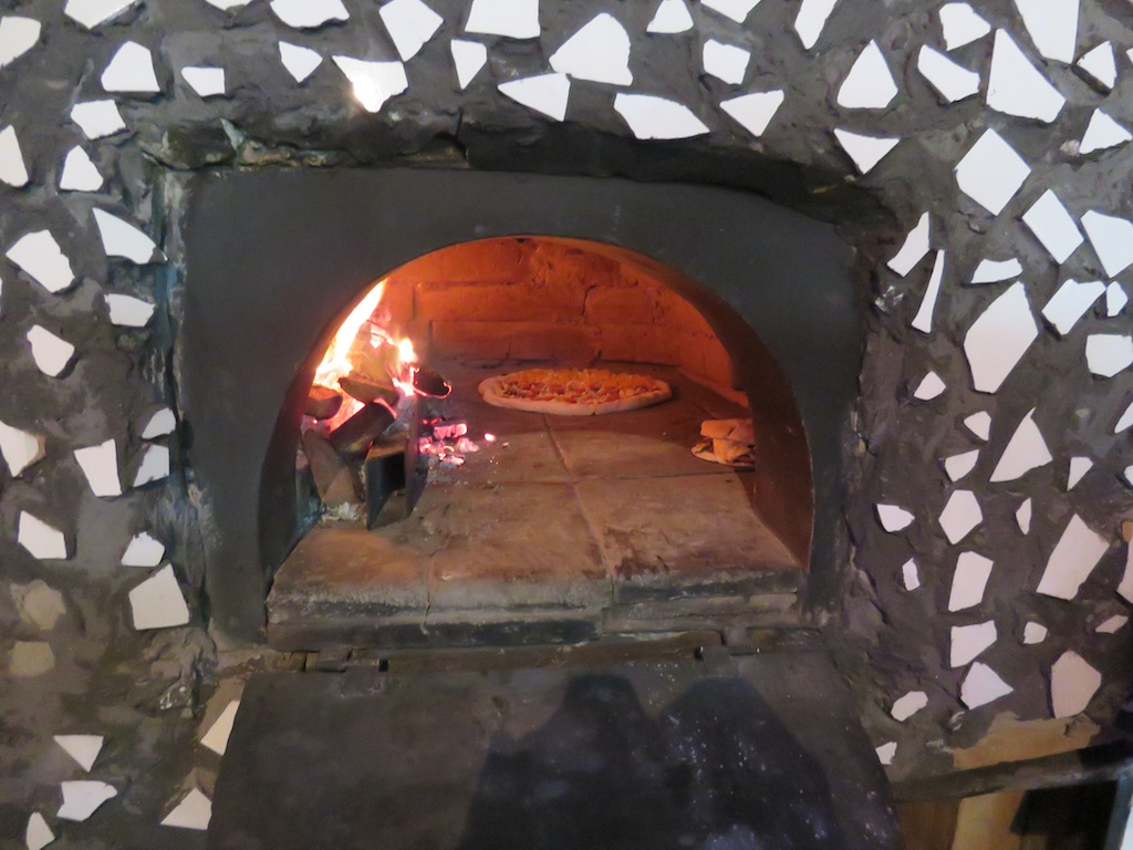 Pizza cocinándose en el horno de ladrillo