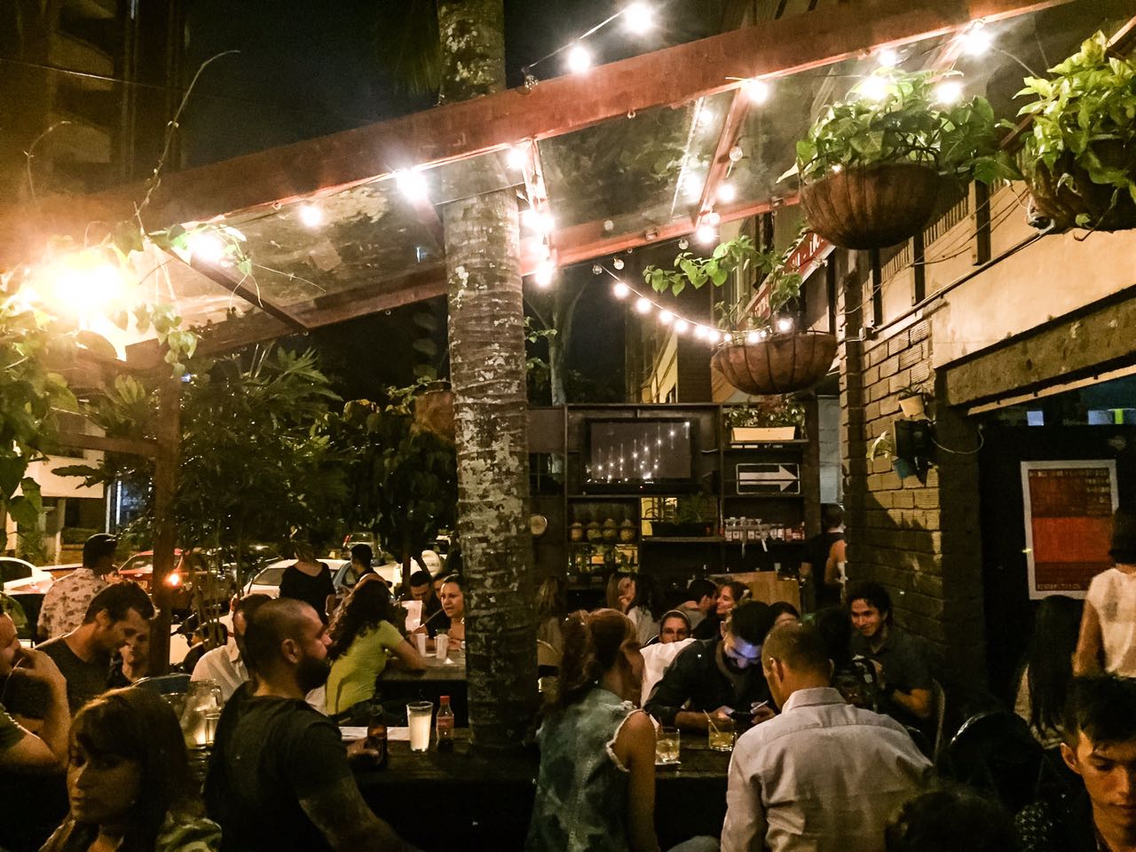 Una buena multitud disfrutando el patio al aire libre en Barrio Central