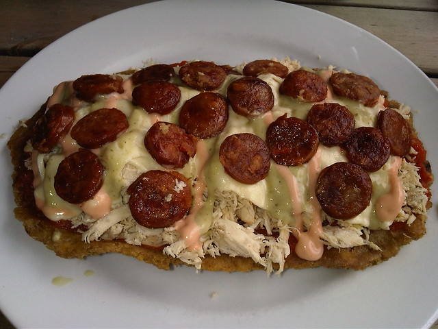 Patacón con Pollo: pollo desmechado, chorizo, guacamole y salsa rosada servidos sobre plátanos fritos. Patacón con Pollo: pollo desmechado, chorizo, guacamole y salsa rosada servidos sobre plátanos fritos.