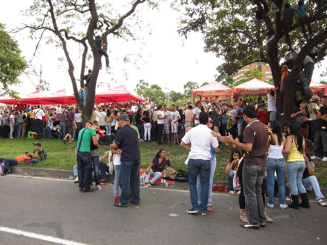 Couples dance in the street while others climb trees for a better view of the parade. Couples dance in the street while others climb trees for a better view of the parade.