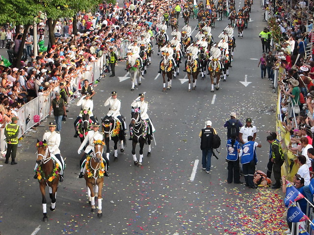 Military on horseback, as a woman who may have been suffering from exhaustion is carried away on a stretcher (right side). Military on horseback, as a woman who may have been suffering from exhaustion is carried away on a stretcher (right side).